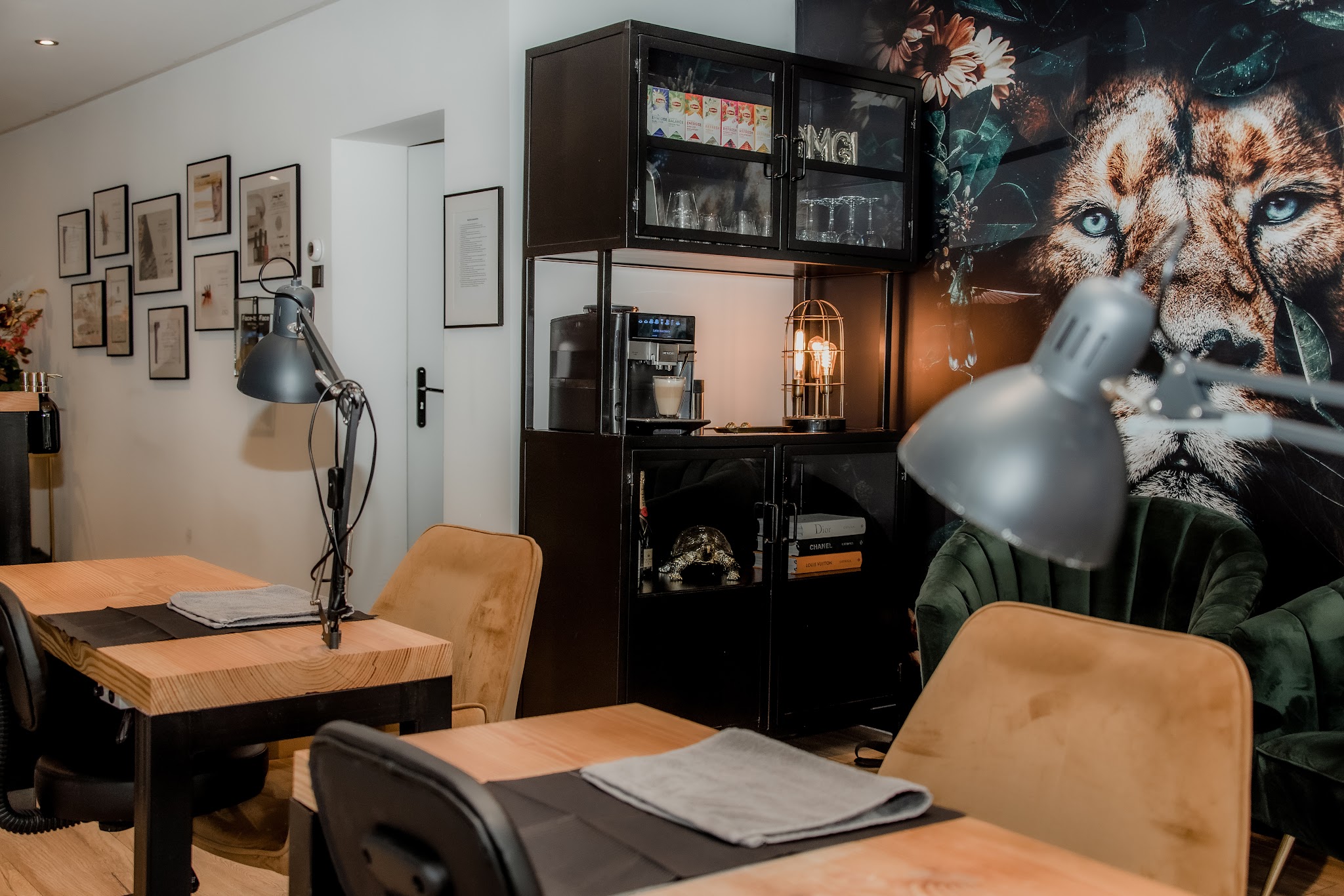 Werktafel met lamp en bruine stoelen, met de leeuwenmuur achterin